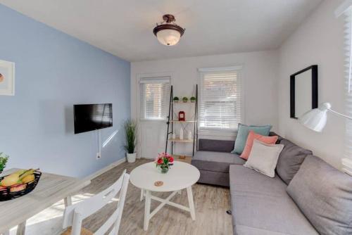 a living room with a couch and a table at Walk to the Best of Midtown Charming Cottage in Memphis