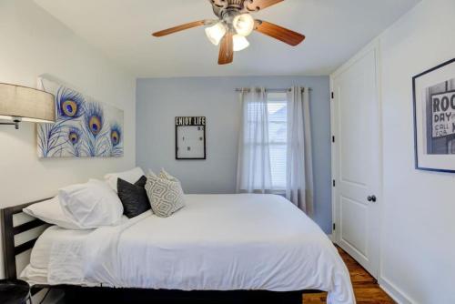 a bedroom with a bed with a ceiling fan at Midtown Cottage Walk to Overton Square in Memphis