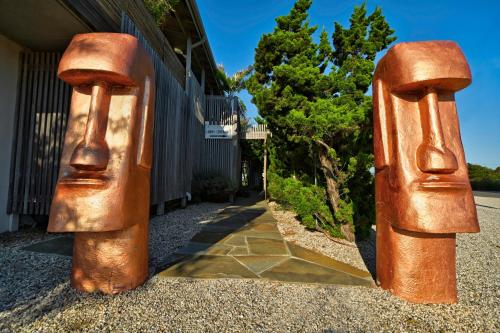 a statue of two hands on the side of a house at The Montauk Beach House in Montauk
