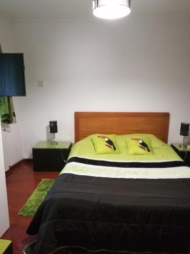 a bedroom with a large bed with yellow pillows at Casa Véronique in Soajo