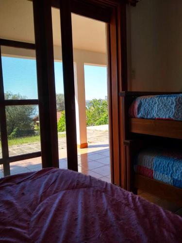 um quarto com uma cama e uma porta de vidro deslizante em Casa Embalsina em Villa del Dique