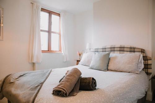 Un dormitorio con una cama con una toalla. en Small Brook Cottage en Hay-on-Wye