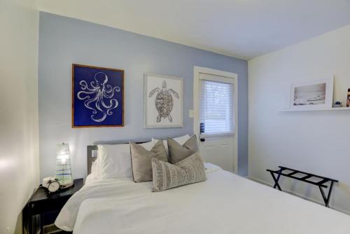 een slaapkamer met een groot wit bed met kussens bij Gated Midtown Cottage with Perfect Location in Memphis