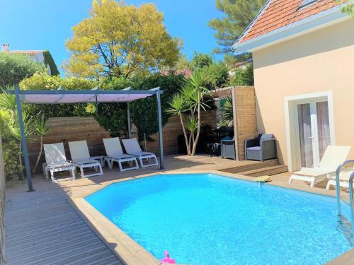 une piscine avec des chaises et une maison dans l'établissement Maison avec piscine et parking à 1,3km des plages, à Cagnes-sur-Mer