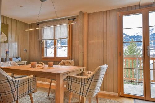 a dining room with a wooden table and chairs at Reste Fidèle Duplex in Fiesch