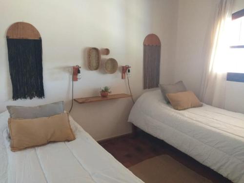 Habitación con 2 camas en una habitación con ventana en Casona Inkill Huasi II en Tilcara