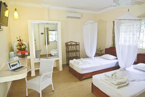 Pokój hotelowy z 2 łóżkami i lustrem w obiekcie Sunset Lounge w mieście Preăh Sihanŭk