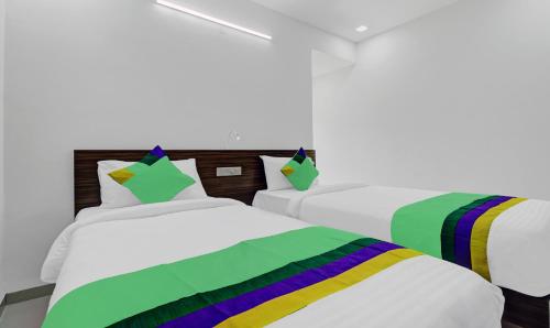 two beds in a room with colorful blankets at Treebo Raga in Visakhapatnam