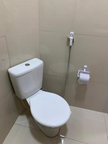 a white toilet in a bathroom with a toilet paper dispenser at Floripa Flat in Areia Branca