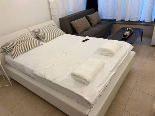 Cama grande en habitación con sofá en דירת סטודיו דקה מחוף הים בת״א, en Tel Aviv
