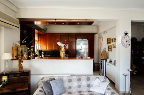 een woonkamer met een bank en een keuken bij AIGIO PARK APARTMENT in Aigio