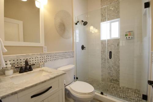 een badkamer met een toilet, een douche en een wastafel bij Upscale 1890s Historic Apartment in Sacramento