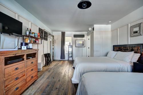 a hotel room with two beds and a flat screen tv at The Montauk Beach House in Montauk