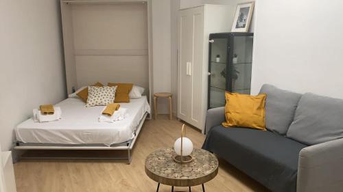 sala de estar con sofá, sofá y mesa en Bonito Estudio con terraza en Madrid