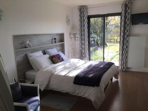 une chambre avec un grand lit et une fenêtre dans l'établissement mise au vert 4 étoiles avec piscine,tennis ,spa, à Grand-Champ