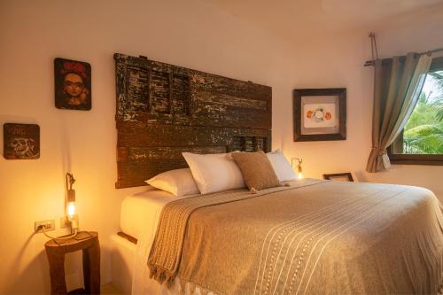a bedroom with a large bed and a window at El Corazón Boutique Hotel - Adults Only with Beach Club pass included in Holbox Island