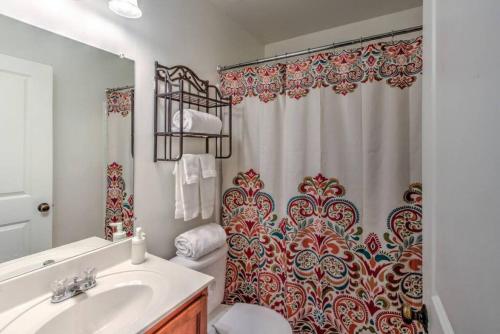 een badkamer met een wastafel en een douchegordijn bij Gated Cottage Community! Ideal Midtown Spot in Memphis