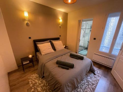 a bedroom with a bed and a large window at Spacieux T2 avec parking à 200 m Cathédrale in Chartres