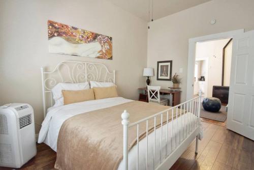 1 dormitorio con 1 cama blanca y ventilador blanco en Historic Charm with Parking in Center of Midtown, en Sacramento
