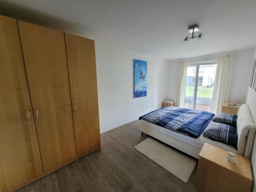 1 dormitorio con 1 cama, armario y ventana en Leipziger Neuseenland Apartment en Markkleeberg