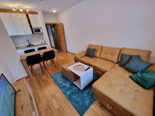 ein Wohnzimmer mit einem Sofa und einem Tisch in der Unterkunft Cozy Ski Apartment Jahorina in Jahorina