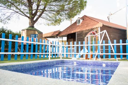 ein Pool vor einem Haus mit einem Zaun in der Unterkunft Bungalow Perotonar Ideal Para Familia Con Niños in La Puebla de Cazalla