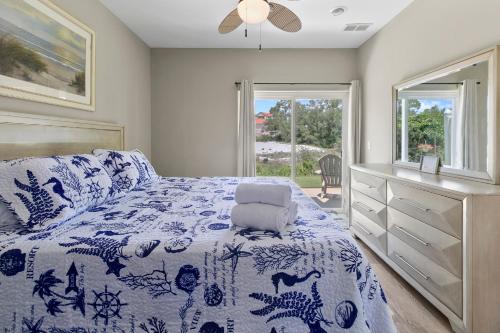 een slaapkamer met een blauw en wit bed en een raam bij Banana Bay 6047 By Pkrm in Pensacola