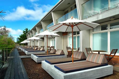 a row of chairs and umbrellas on the side of a building at The Montauk Beach House in Montauk