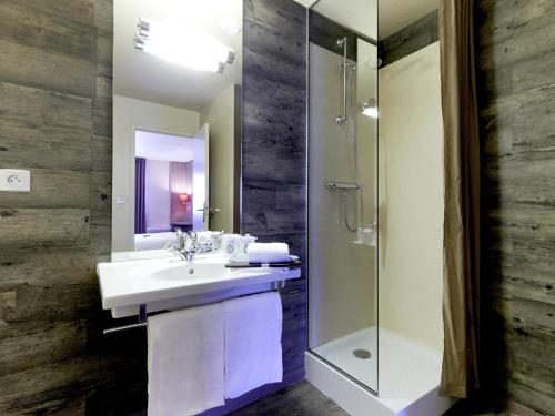 een badkamer met een wastafel en een douche bij Kyriad Cholet in Cholet