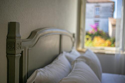a bedroom with a bed with white pillows and a window at Revelin Hvar in Stari Grad