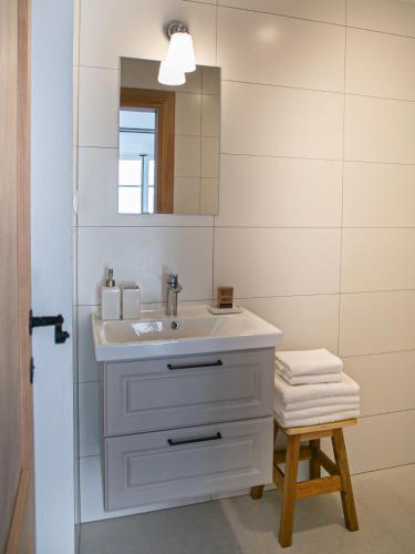 a bathroom with a sink and a mirror and a stool at Revelin Hvar in Stari Grad