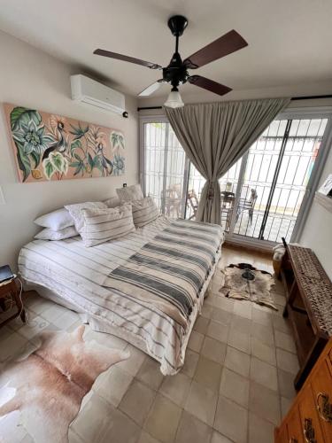 Casa Azul en Barrio Privado في San Pablo: غرفة نوم بسرير كبير ومروحة سقف