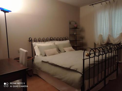 um quarto com uma cama grande e uma cabeceira em ferro forjado em B&B I Sassetti em Foligno