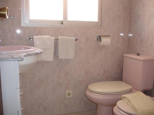 a bathroom with a toilet and a sink at Las Palmeras - Zand Properties in Benidorm