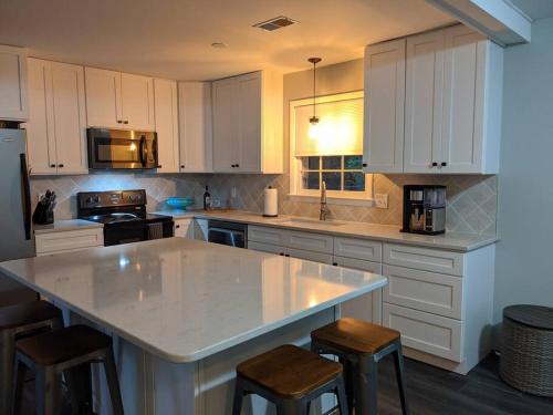 uma cozinha com armários brancos e um balcão branco em Wilmington Family Vacation Home em Wilmington