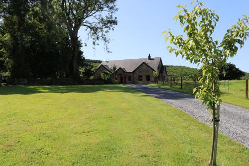 an old house with a tree in front of a driveway at Loughcrew View Bed and Breakfast in Kells