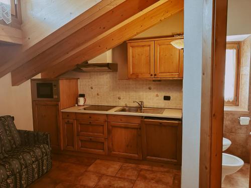 una cocina con armarios de madera y fregadero en Appartamenti Lumaca, en Livigno