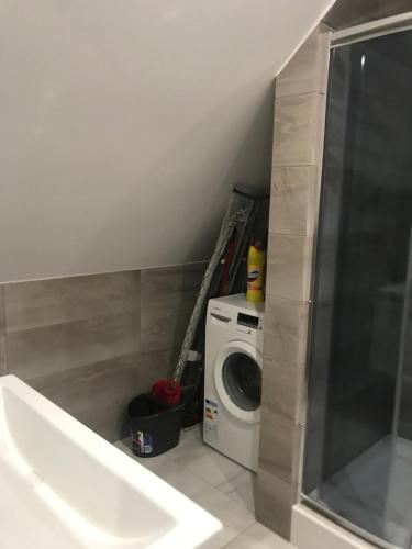 a bathroom with a washing machine and a washer at Apartament, noclegi na doby - Raczki k. Suwałk in Raczki