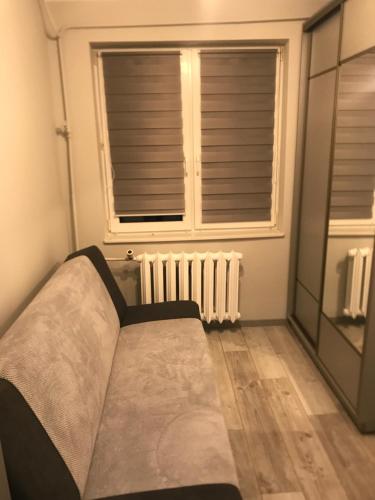 Cama en habitación con ventana y radiador en Apartament, noclegi na doby - Raczki k. Suwałk, en Raczki