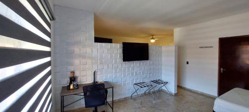 - un salon avec une télévision sur un mur blanc dans l'établissement Palmareca Inn-Suites-Studio, à Tuxtla Gutiérrez
