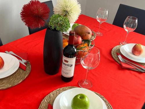 - une table rouge avec une bouteille de vin et des verres à vin dans l'établissement Calle Mora De Rubielos with Free Private Underground Parking, à Valence