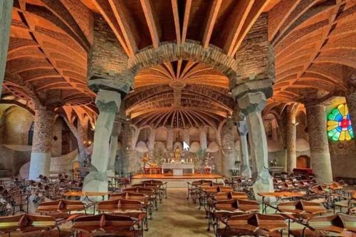 Habitación grande con mesas y sillas en una iglesia. en Precioso Piso Barcelona, en Santa Coloma de Cervelló