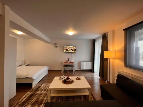 a hotel room with a bed and a coffee table at Libertatii Gardens Residences in Otopeni