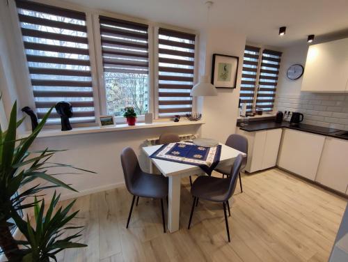 a kitchen and dining room with a table and chairs at Nowoczesny apartament w sercu Wrocławia in Wrocław