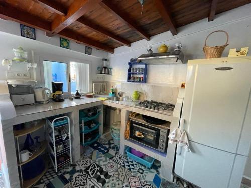 a kitchen with a white refrigerator and a tile floor at Coco Chawen in Chefchaouen