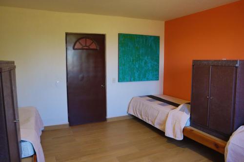 um quarto com uma cama e piso em madeira em MASIA ARAMENI em Umecuaro