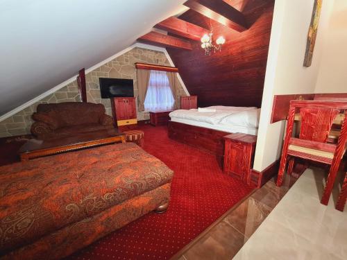 a attic bedroom with two beds and a chair at Villa Rusalka in Tatranská Kotlina