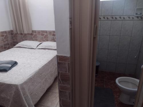 a small bathroom with a bed and a toilet at Meu Cantinho E in Guaratinguetá