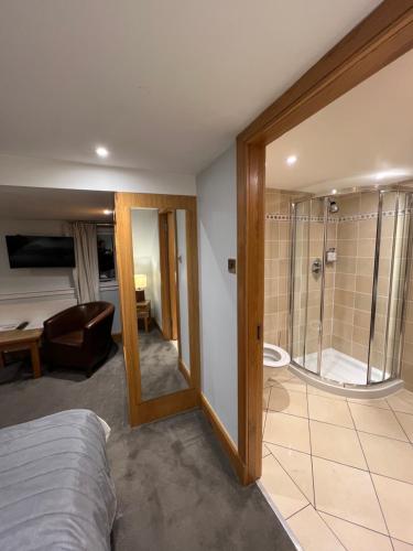 a room with a bed and a bathroom with a shower at The Ship Inn in Gatehouse of Fleet