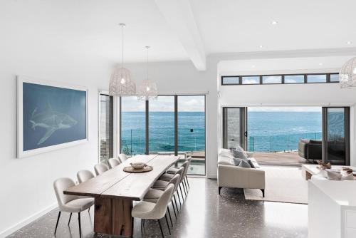 a dining room with a table and chairs at Surf Beach House in Shellharbour
